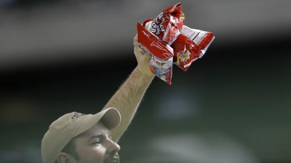 Peanut vendor holding peanut bags